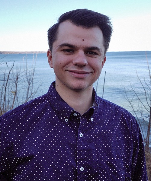 Andre Vandlik profile photo, standing in front of a lake